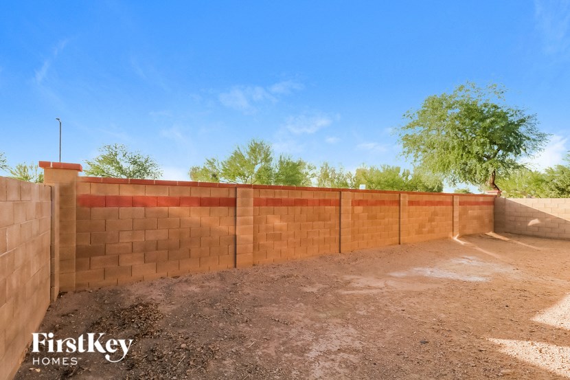 a brick retaining wall with a brick fence and a tree