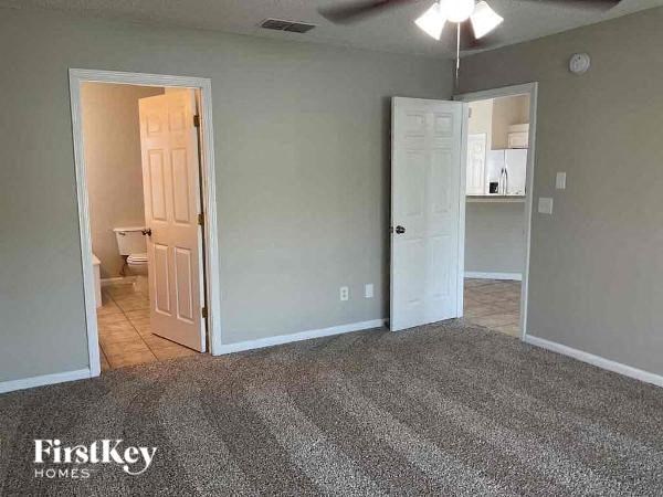 an empty living room with a door to a bathroom