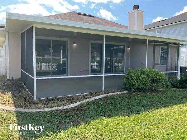 a house with a screened in porch and grass