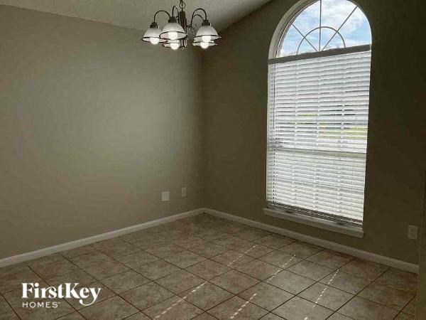 an empty room with a large window and tiled floor