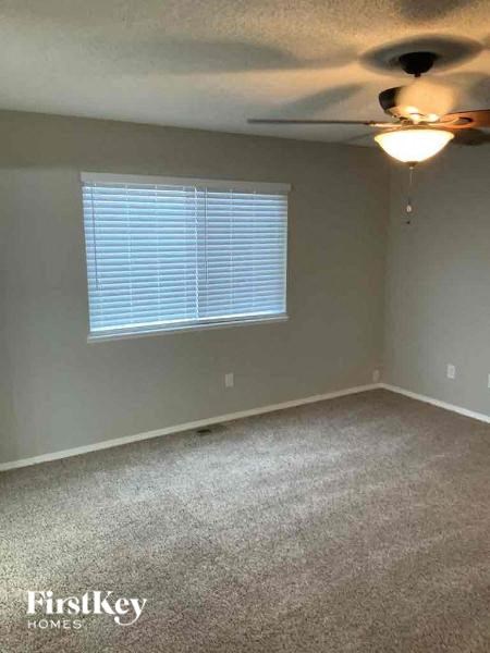 an empty room with a ceiling fan and a window