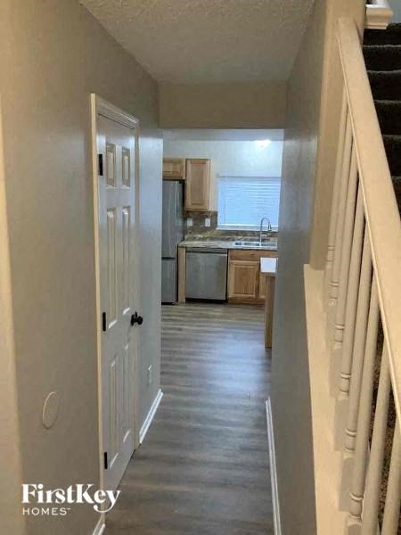 a hallway with a staircase and a kitchen