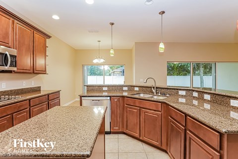 A kitchen with brown cabinets and granite countertops.