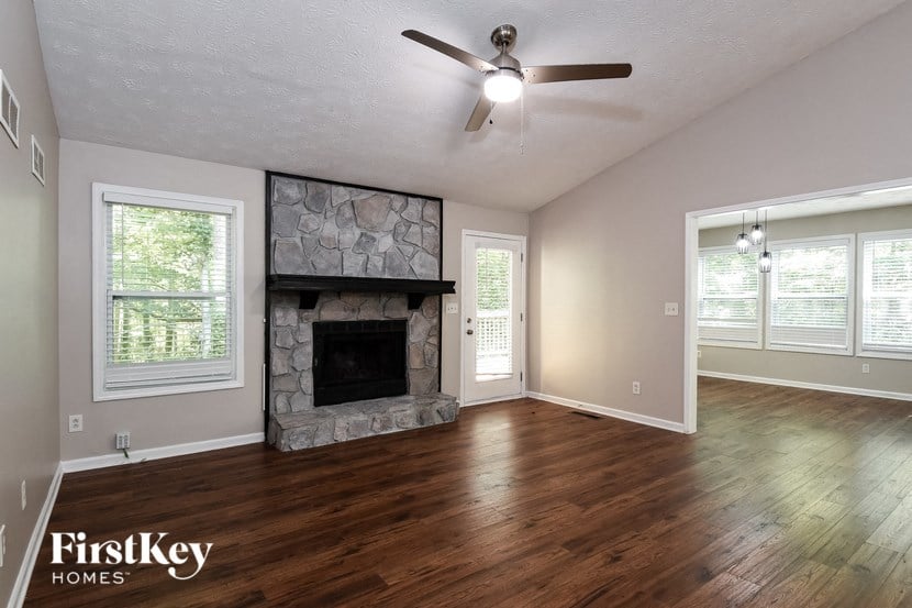 A room with a fireplace and a ceiling fan.