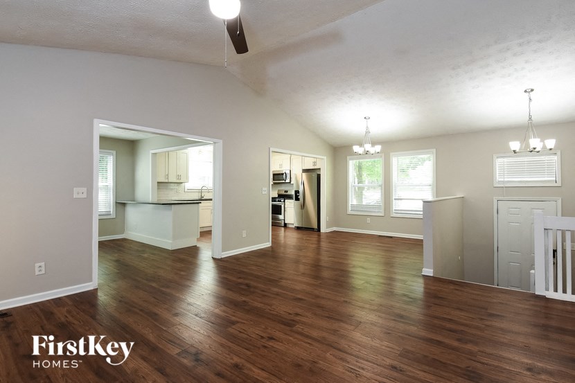 A spacious living room with wood flooring and a ceiling fan.