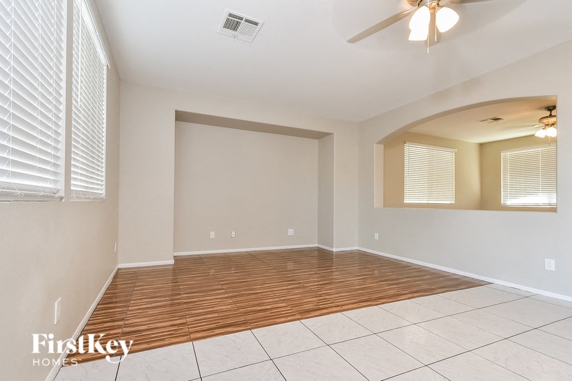 the living room is clean and empty with a ceiling fan