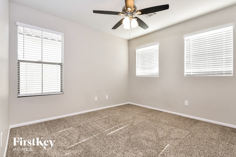 the master bedroom has a carpeted floor and a ceiling fan
