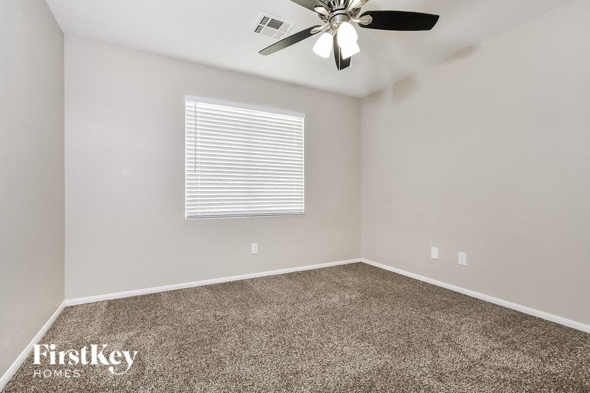 a room with carpet and a ceiling fan