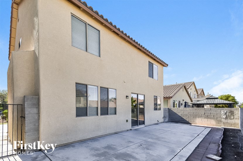 a large beige house with a driveway and a gate