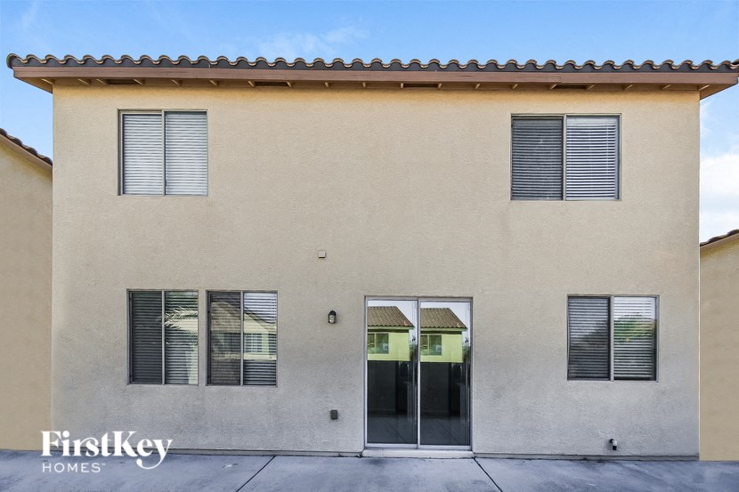 the front of a building with two doors and a sidewalk