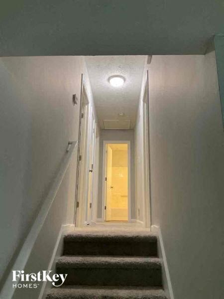 A stairway leading to a door with a light on the ceiling.