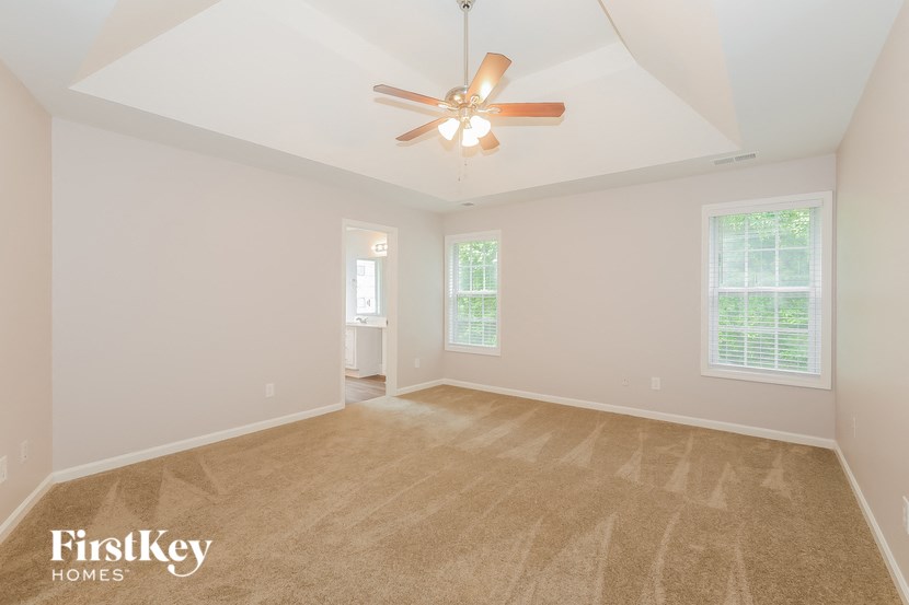 an empty living room with a ceiling fan