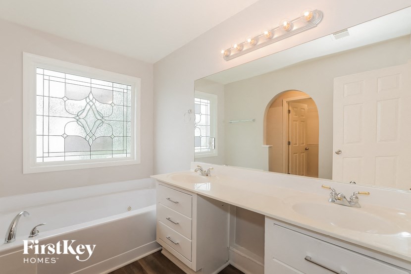 a bathroom with a sink and a mirror and a tub