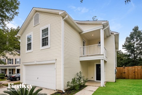 A two-story house with a garage and a balcony.