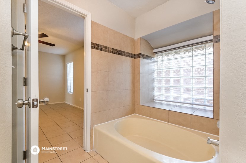 a bathroom with a tub and a shower and a window