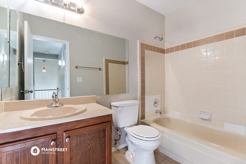 a bathroom with a sink toilet and tub and a mirror