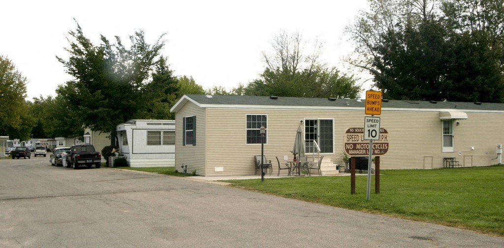 a mobile home sits on the side of a road in a trailer park