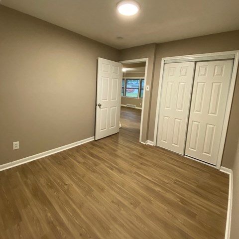 a living room and hallway with wood floors and white doors
