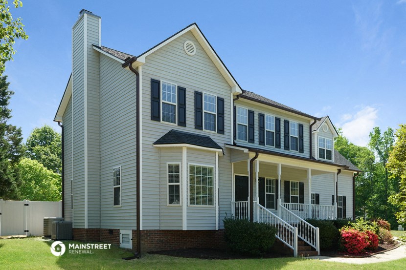 a house with white siding and black shutters and a lawn