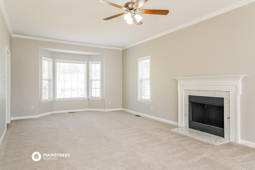the living room with fireplace and ceiling fan