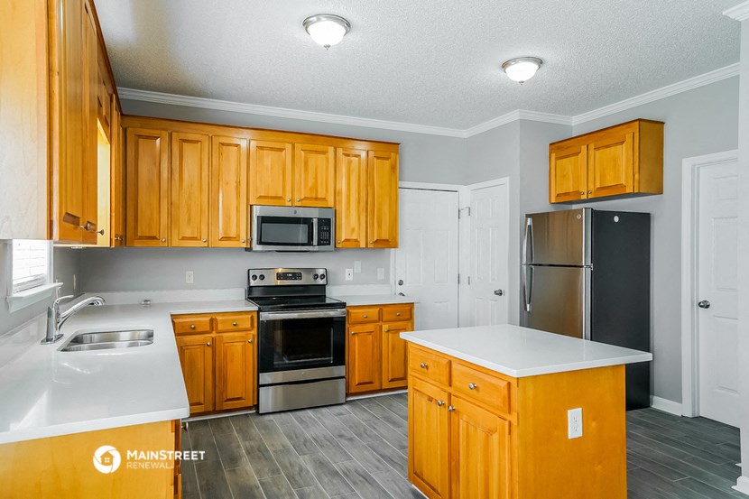 a kitchen with wooden cabinets and stainless steel appliances