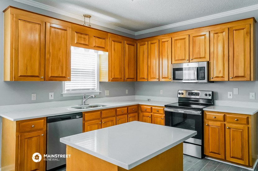a kitchen with wooden cabinets and a white counter top