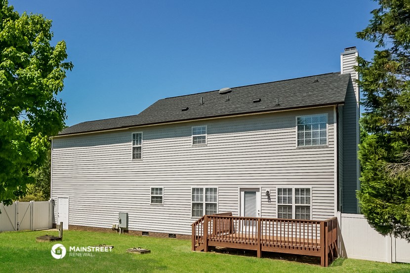 a wooden deck in front of a white house
