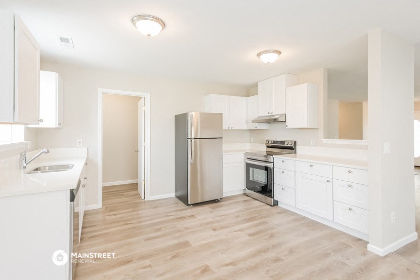 a renovated kitchen with white cabinets and stainless steel appliances