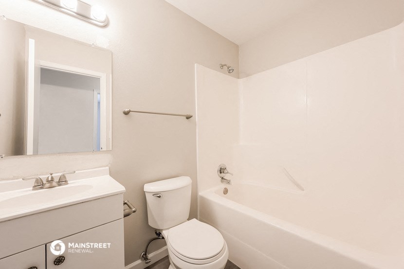 a bathroom with a toilet and a tub and a sink