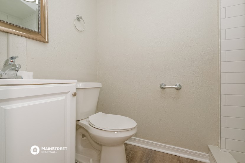 a bathroom with a toilet and a sink and a mirror