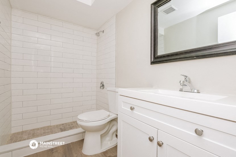 a bathroom with a toilet and a sink and a mirror