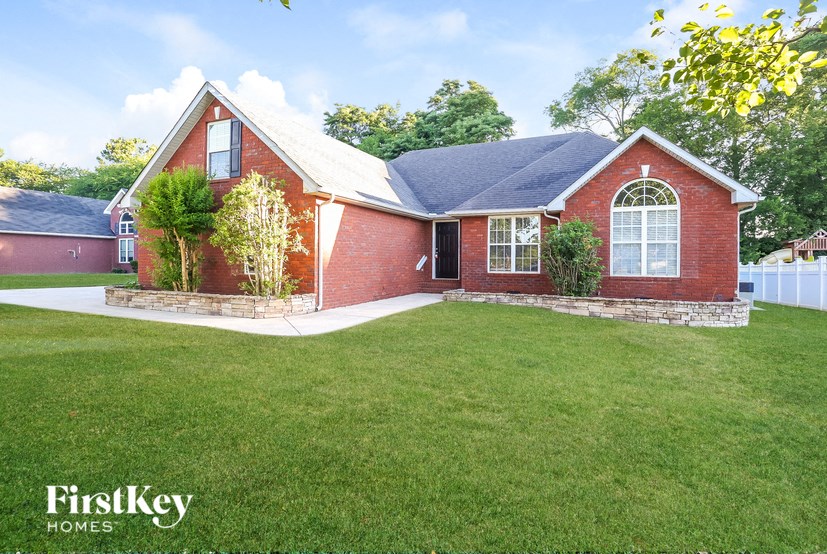 a red brick house with a yard and a lawn