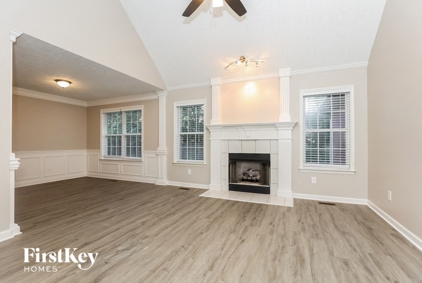 a living room with a fireplace and wooden floors
