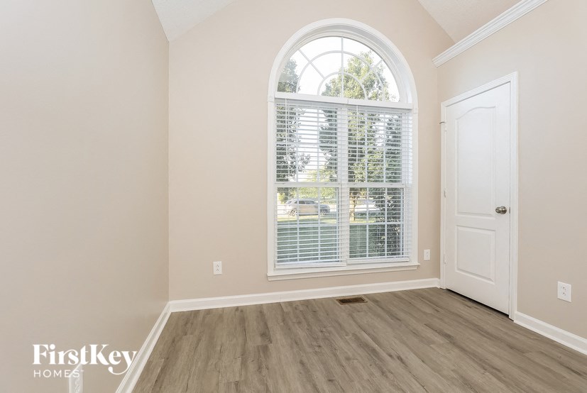 a living room with a large window and wooden floors