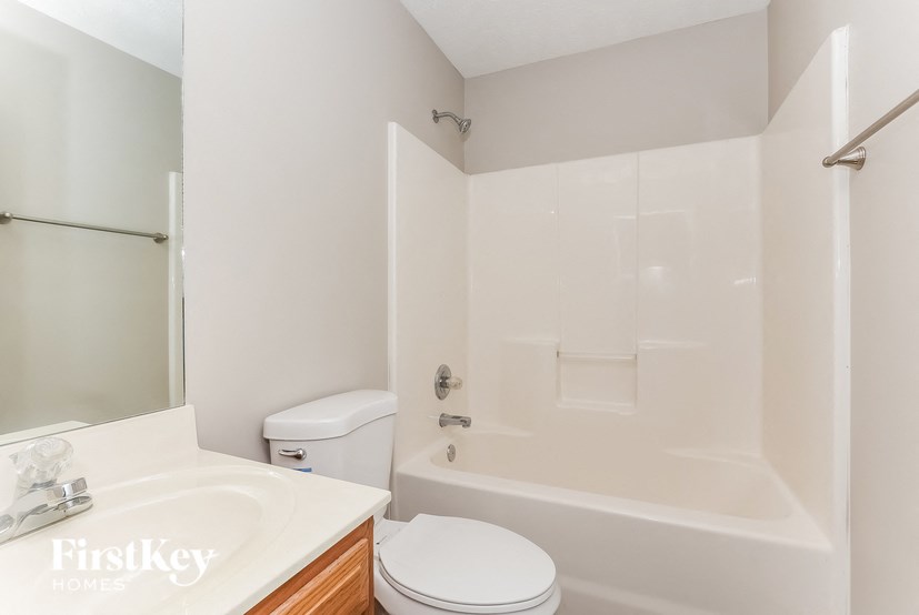 a white bathroom with a toilet and a tub and a sink