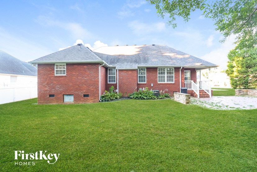 a red brick house with a green lawn