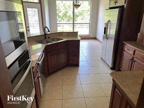 A kitchen with wooden cabinets and a tiled floor.