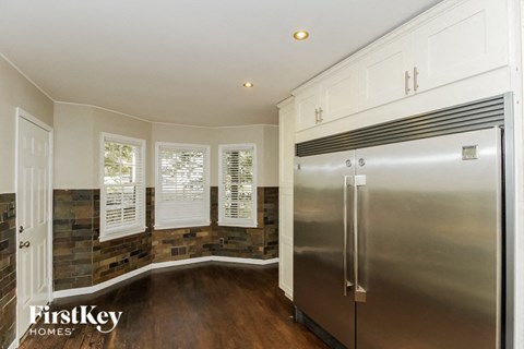 a kitchen with a stainless steel refrigerator and white cabinets