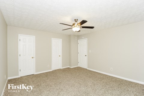 a bedroom with two doors and a ceiling fan