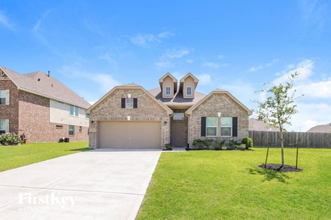 a large brick house with a garage and a lawn