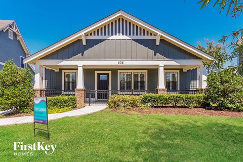a home with a lawn and a sign in front of it