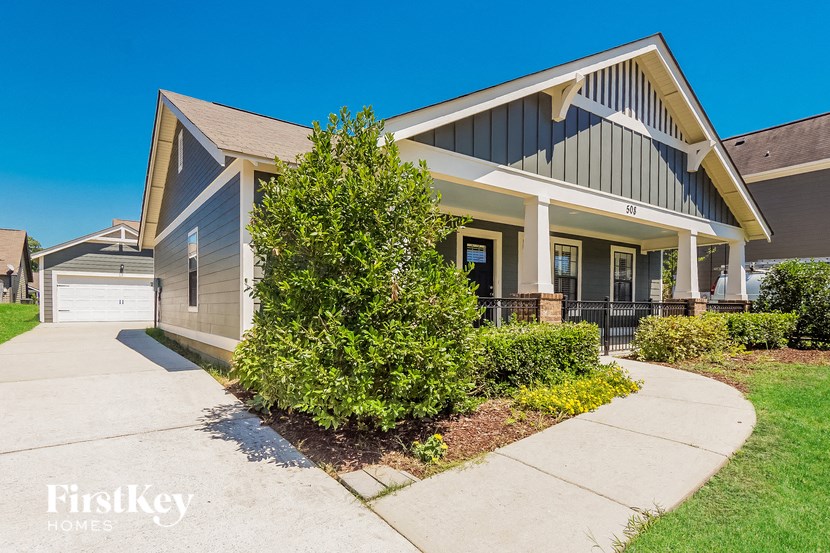 the front of a house with a sidewalk in front of it