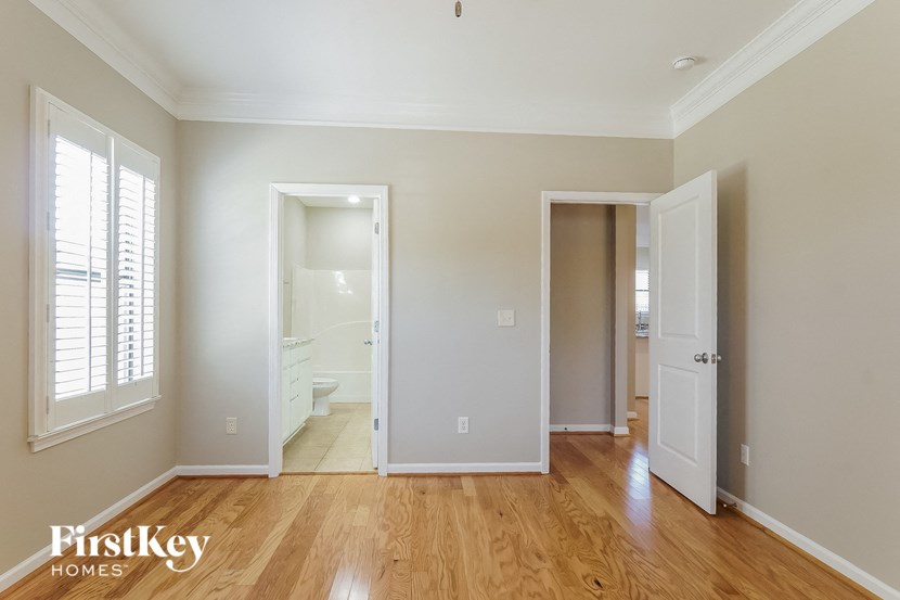an empty living room with a door to a bathroom and a closet