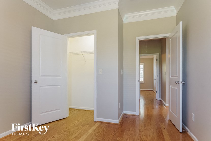 a bedroom with two closets and a hallway with a door to a closet