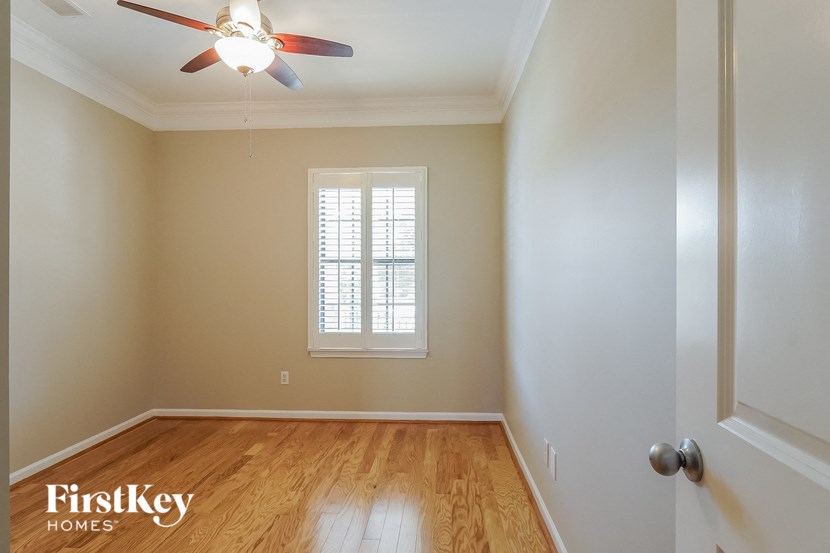 a empty room with a ceiling fan and a window