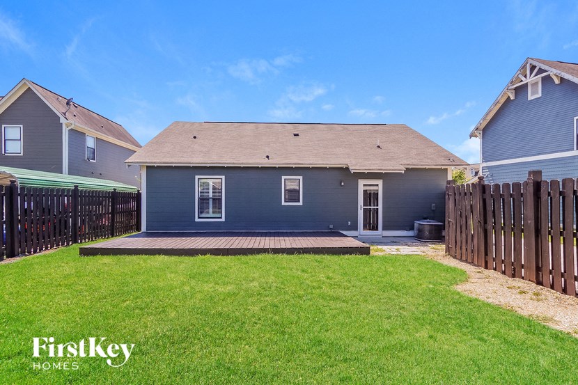 a blue house with a yard and a wooden fence