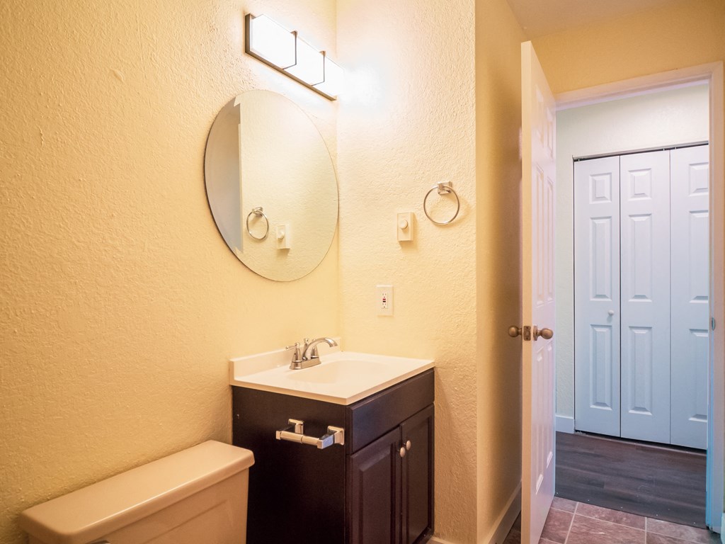 a bathroom with a sink and a mirror and a door