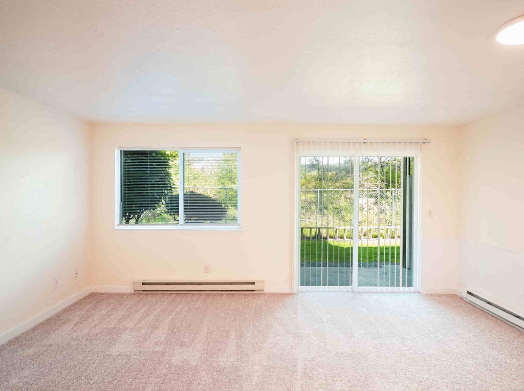 an empty living room with a door to a patio