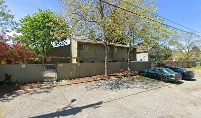 a house with a fence and cars parked in front of it