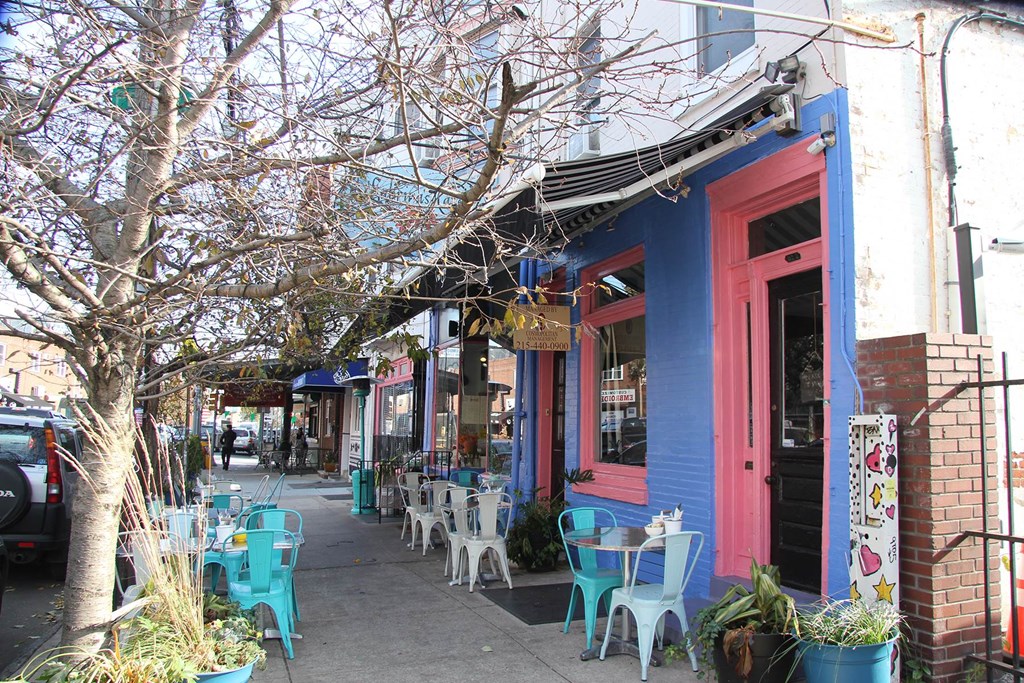 a street with tables and chairs outside of a building